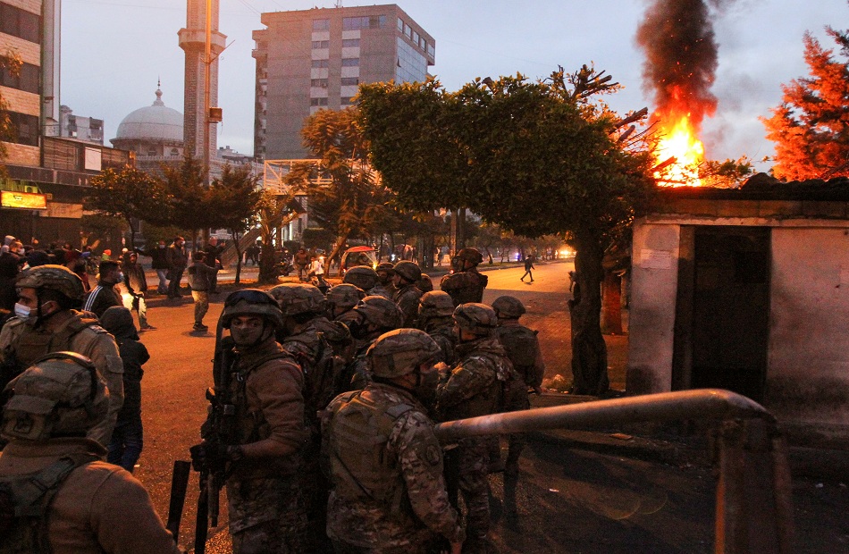 Army soldiers stand guard near the government Serail building during a protest in Tripoli