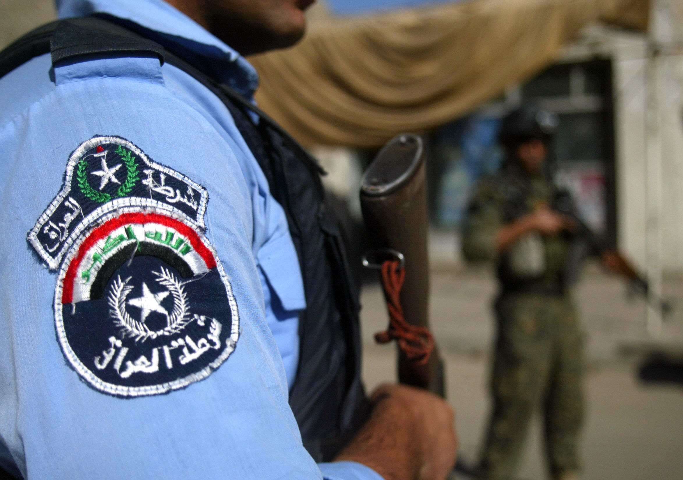 An Iraq police man stands with Iraqi sol